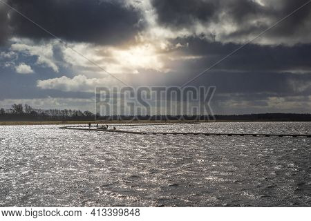 Sun Breaking Through The Dark Clouds Over The Lake In Roegwold, Netherlands