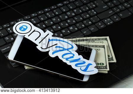 Kharkov, Ukraine - February 14, 2021: Onlyfans Paper Logo With Smartphone And Dollar Bills On Black 
