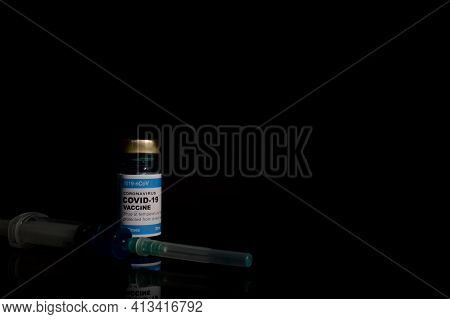 Coronavirus Covic-19 Bottle Vaccination And Syringe Over Black Background