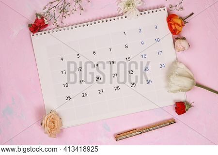 Close Up Calendar With Flowers And A Beautiful Handle On Pink Stone Background In Planning Concept.