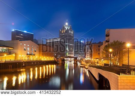 Milwaukee, Wisconsin, USA downtown skyline on the Milwaukee River in the evening.