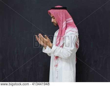 Arab man in traditional clothes praying to God or making dua