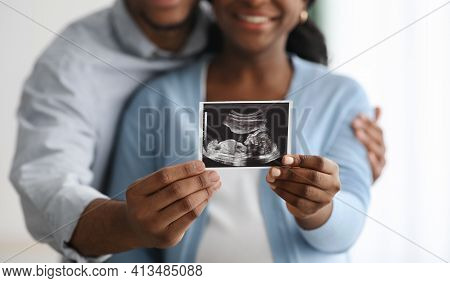 Closeup Of Baby Sonogram In Black Couple Hands