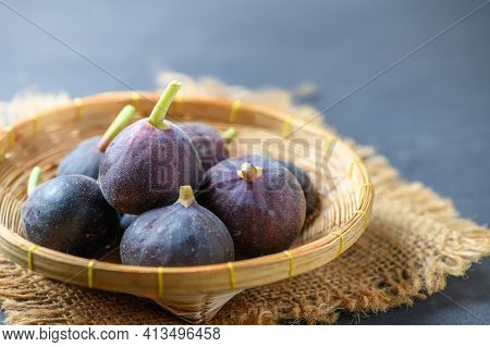 Fresh Ripe Figs In Bamboo Basket On Dark Table. Healthy Mediterranean Fig Fruit. Fresh Figs On Black