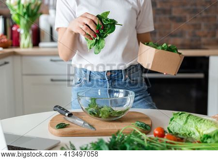 Close Up Woman In White T-shirt Cooking Salad With Motion Effect At Home Kitchen. Process Of Cooking