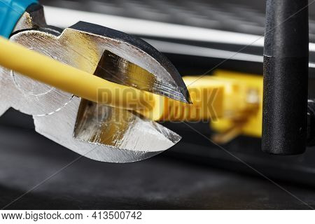 Tearing And Cutting With Blue Wire Cutters The Network Connection Of The Yellow Wire Of The Internet