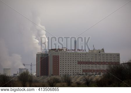 Bucharest, Romania - March 20, 2021: Rin Grand Hotel In Bucharest, With A Fuming Power Station In Th