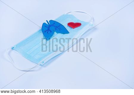 Paper Lungs And Red Heart On Protective Mask, Blue Background. World Tuberculosis Day. Prevention Co