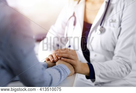 Unknown Woman-doctor Is Holding Her Patients Hands To Reassure The Patient, Discussing Current Healt