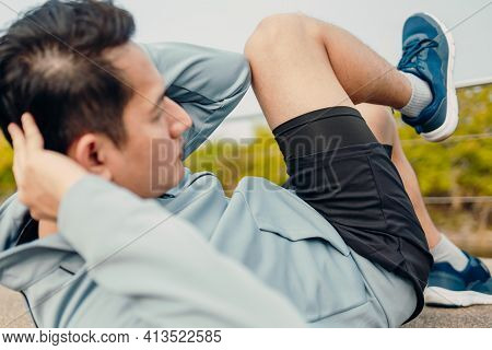 Young Sportsman Doing Cyling Crunches In Park.