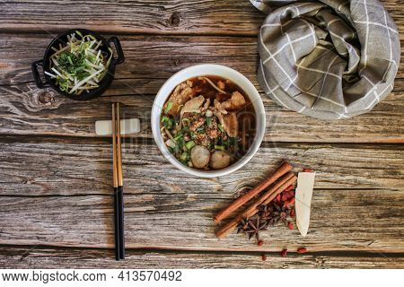 Egg Noodle With Pork And Vegetable In Five Spices Black Soup On Wooden Table Top View