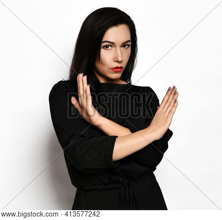 Stern, Severe-looking Pretty Brunette Woman In Stylish Casual Black Dress Stands Gesturing Cross No 
