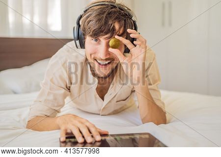 Young Man, A Digital Artist, Dj Creates Digital Art On A Tablet At Home And Shows A Coin With The In