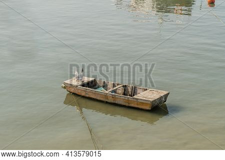 Two Seagulls On Small Wooden Boat Floating In Ocean Port.