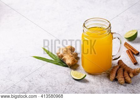 Healthy Drink From Turmeric And Ginger Roots And Lime In A Glass On White Concrete Background With C
