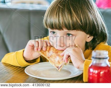 Eight-year-old Boy Is Eating Crepes In A Cafe. Portrait. Close-up.