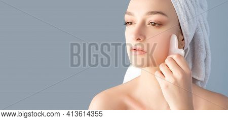 Guasha Face Massage. Beauty Banner. Alternative Skincare. Woman With Nude Makeup Bare Shoulders Towe