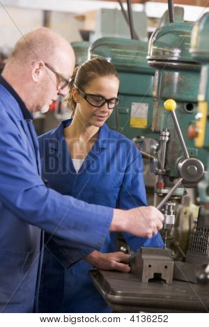 Two Machinists Working On Machine