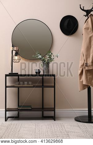 Console Table, Clothes Rack And Mirror On Beige Wall In Hallway. Interior Design