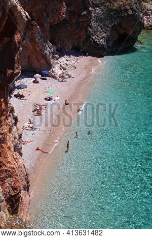 Konavle, Croatia - June 28, 2019: People Spend Vacation At Pasjaca Beach Below Cliffs In Konavle Reg