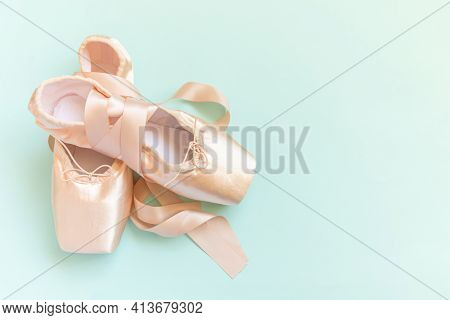 New Pastel Beige Ballet Shoes With Satin Ribbon Isolated On Blue Background. Ballerina Classical Poi