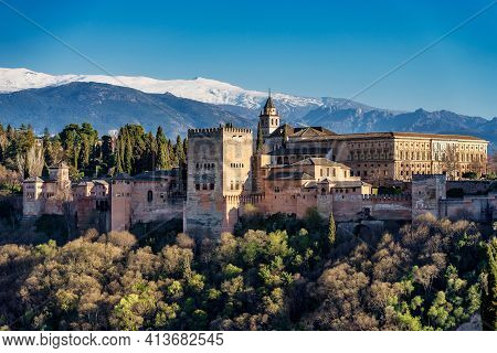 View Of Alhambra Palace In Granada, Spain With Sierra Nevada Mountains At The Background