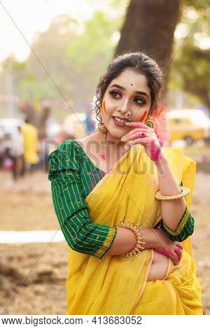 Portrait Of Beautiful Happy Young Indian Woman With Spring Festive Make Up Celebrating Holi With Pow