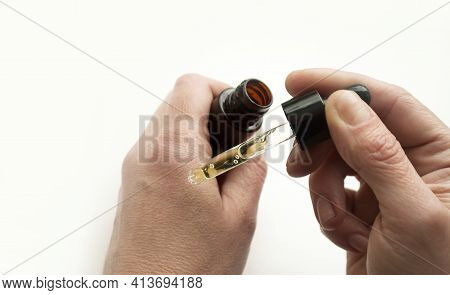 Cropped View Of Woman Applying Liquid From Glass Bottle, Woman Age Forty Plus. Apply A Moisturizer W