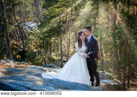 Beautiful Couple On Their Wedding Day Against The Background Of An Epithetical Sunset In The Mountai