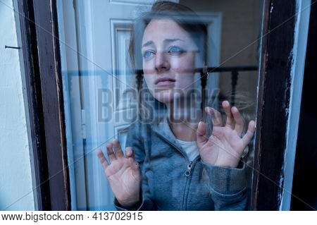 Young Attractive Unhappy Woman Suffering From Depression Looking Lost Through The Window At Home