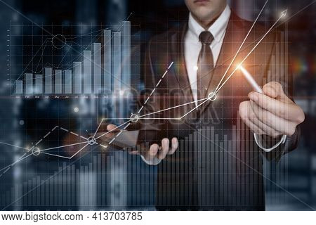 Business Man Analyzing Financial Growth Graph On Blurred Background.