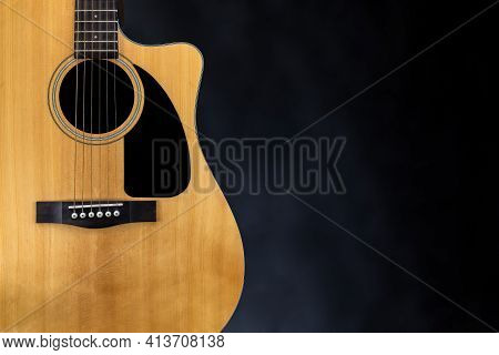 Sound Board Of Classic Yellow Acoustic Guitar With Black Pickguard And Strings Near Isolated Black B