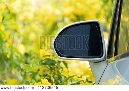 Close-up Edge Of The Side Mirror Car White Color. And Bright Yellow Trumpet Shaped Or Bignoniaceae F