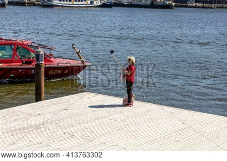 Amsterdam, Netherlands - July 02, 2018: A Tourist Takes A Selfie On The Background Of A Floating Boa