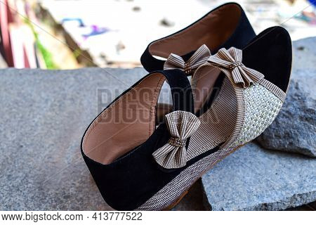 Stock Photo Of Beautiful Pair Of Black And Cream Color High Heel Sandals Displayed On Blur Backgroun