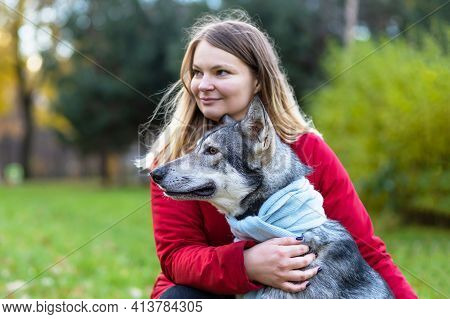 Young Happy Woman Hugging Dog. Pet Adoption.  Czechoslovak With Female Owner. Caucasian Girl Walking