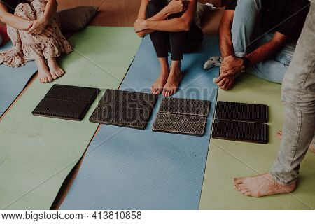 Group Practice Of Standing On Nails. Closeup Of Yoga Person Standing On Sadhu Board With Sharp Nails