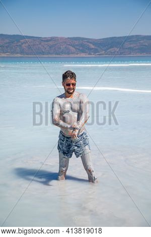 Happy And Funny Male Tourist Takes Smears Natural Cosmetic Clay To His Body On Salda Lake, Turkey