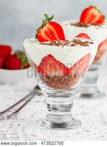 Layered Dessert Of Chocolate Sponge Cake, Whipped Cream Or Ricotta And Fresh Strawberries In A Glass