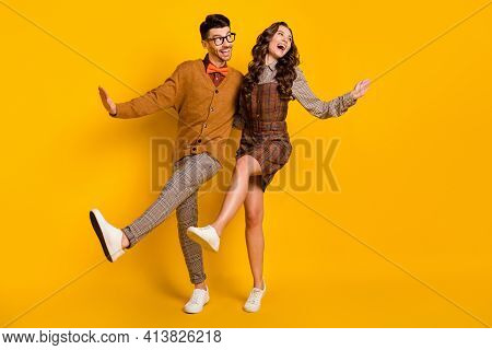 Full Length Photo Of Funny Happy Man And Woman Couple Look Empty Space Dance Raise Leg Isolated On Y