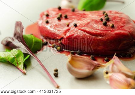 Raw Beef Sirloin Steak With Peppercorns And Garlic Prepared For Frying