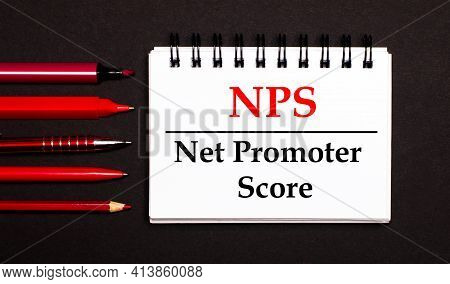 A White Notepad With The Text Nps Net Promoter Score, Written On A White Notepad Next To Red Pens, P