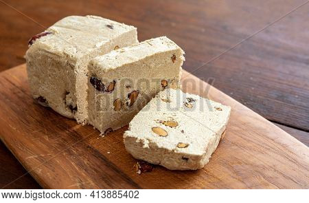 Halva Almond Nuts Slices On Wooden Table Background