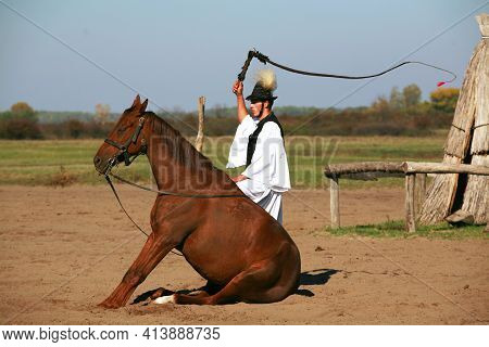 Puszta, Hungary, September, 04. 2020: Hungarian Herdsmen As Csikos In Traditional Folk Costume Showi