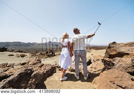 A Stylish Woman Takes A Selfie In The Crater Of The Teide Volcano. Desert Landscape In Tenerife. Tei