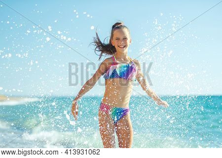Child Girl Runs On The Waves. Rest By The Sea, Fun Outdoors. High Quality Photo.
