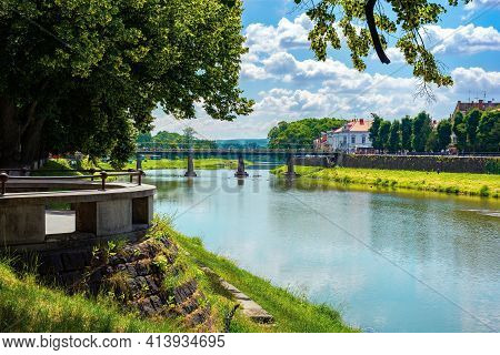 Embankment Of The River Uzh. Wonderful Urban Scenery In Summer. View From Beneath The Shadow Of A Li