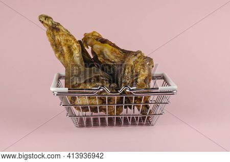 Shopping Basket With Dog Treats On A Pink Background. Chewy Treats In Metal Basket. Dried Beef Ears 