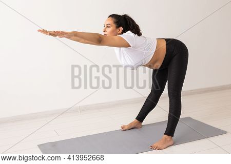 Young Flexible Pregnant Woman Doing Gymnastics On Rug On The Floor On White Background. The Concept 