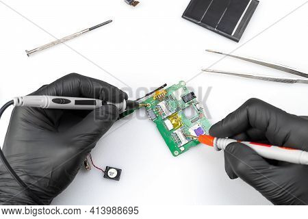 Master Of Radio Engineering Repairs A Part Of The Mobile Phone, Making Measurements On It With A Dig